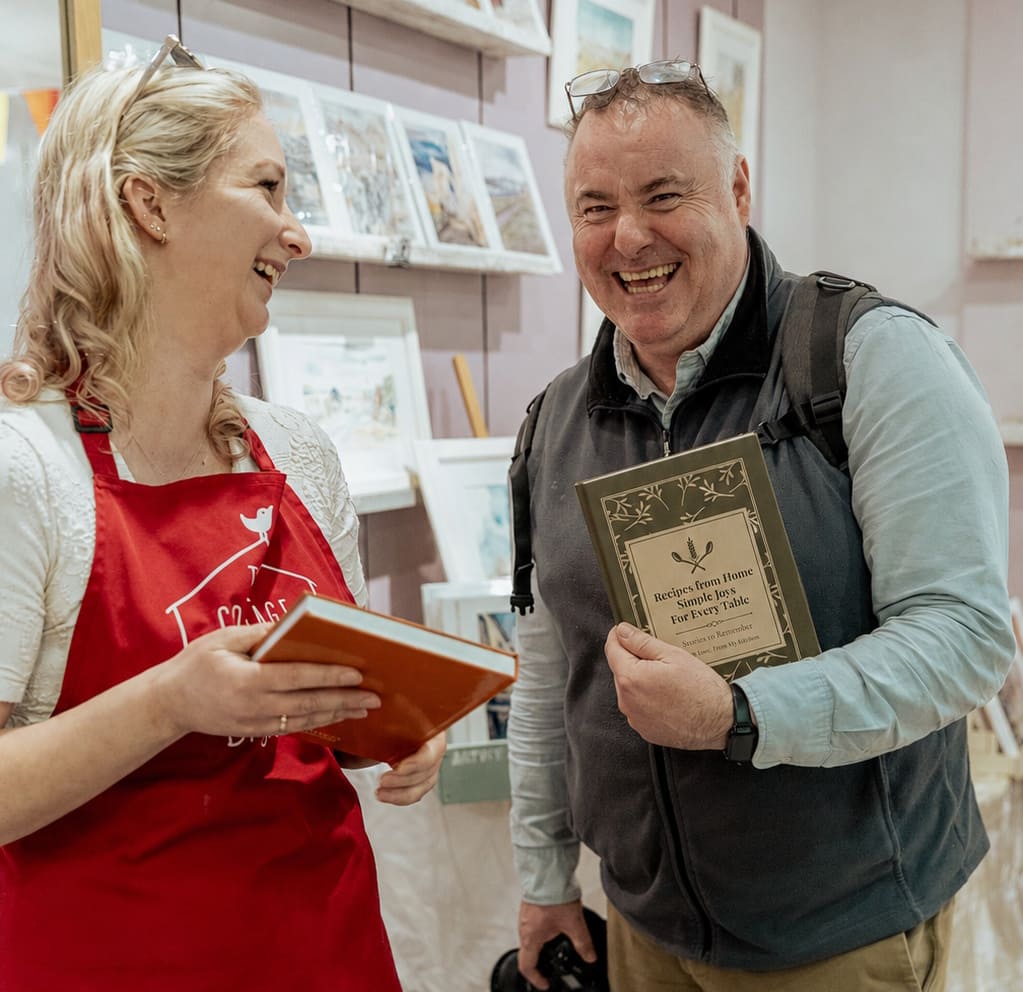Two people sharing a Tasteful Memories family cookbook