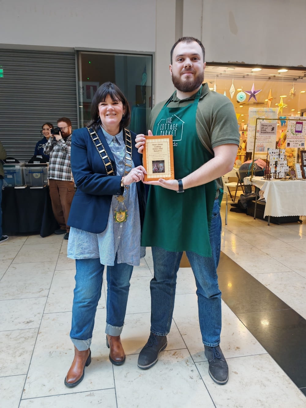 A finished Tasteful Memories cookbook being shared with the Mayor